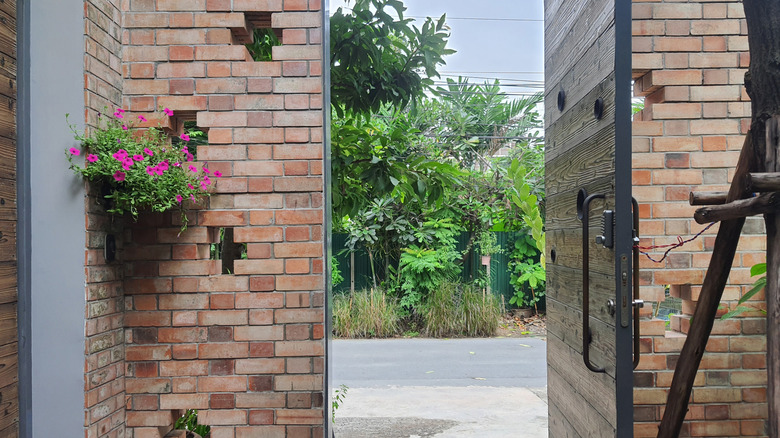 An open Yakisugi wood door on a brick building