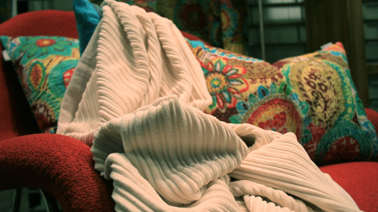 Comfortable sofa with several throw pillows and a blanket