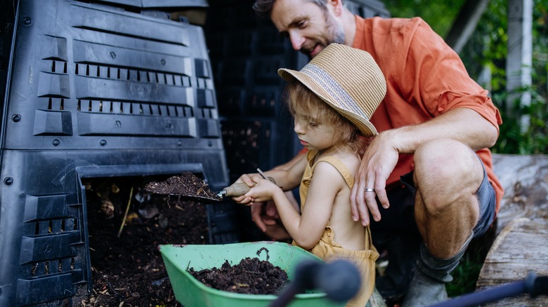 Father teaching child to compost
