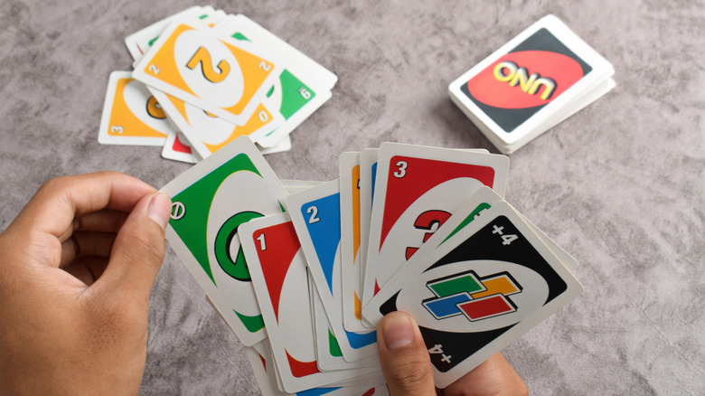 Hands holding the card game Uno