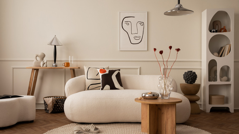 Living room with chrome lighting and decor mixed with warm wood and natural textures, white sofa