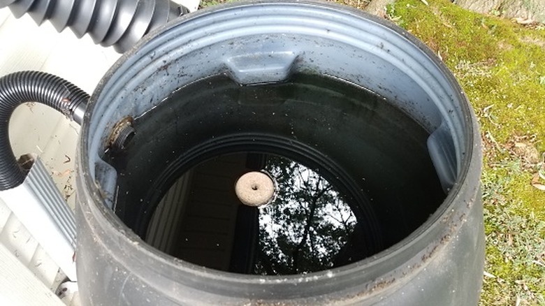 A larvicide block on the side of a rain barrel