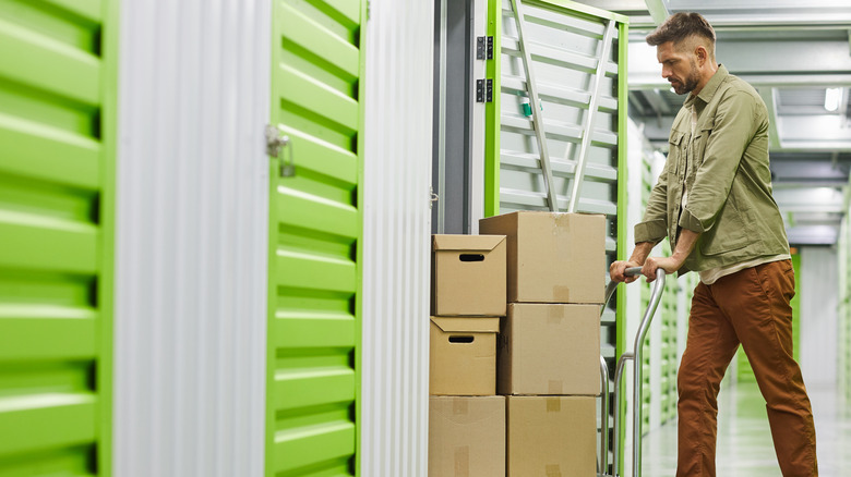 Man pushing boxes into storage