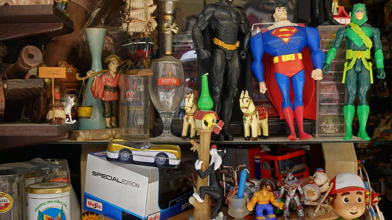 Display of vintage collectables, with Batman, Superman, and other dolls