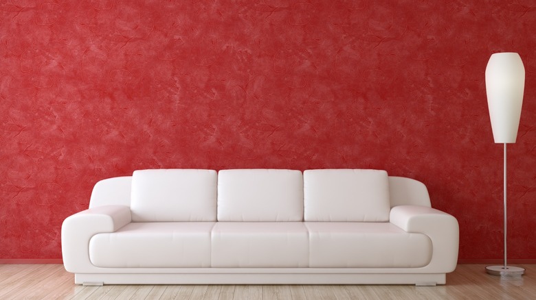 white leather couch, red wall