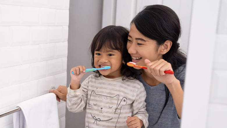 Mother and daughter brushing teeth 