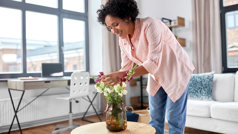 Woman arranging flowers in vase