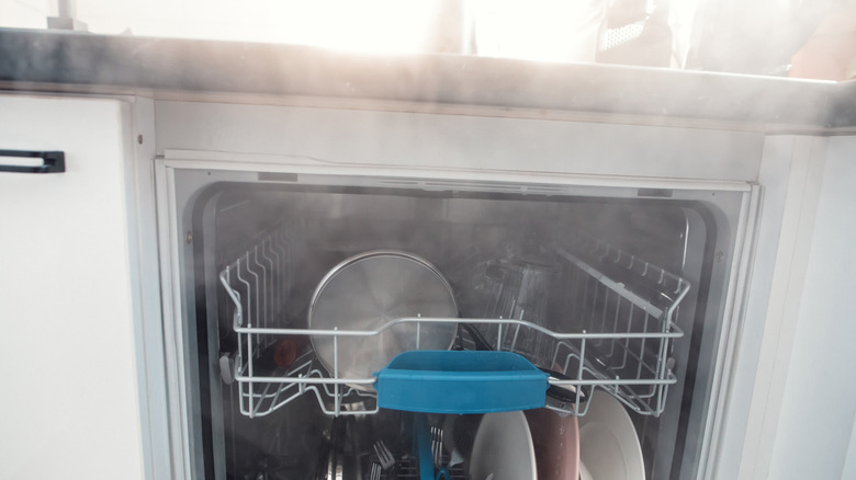 Open dishwasher with steam coming out