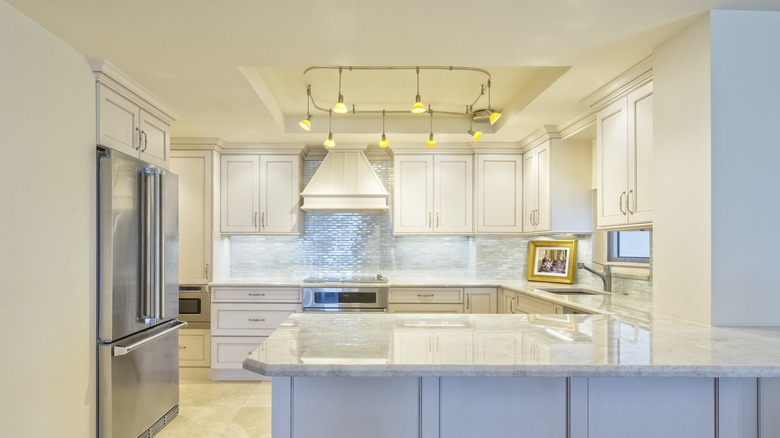 G-shaped white kitchen design with peninsula
