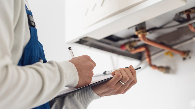 plumber writing on clipboard