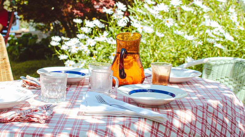 Pitcher of water and glasses on a table in a garden