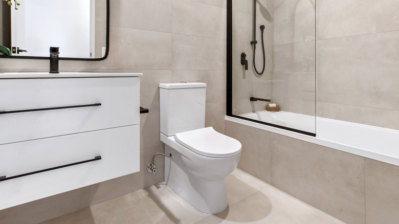 A white toilet on a tiled bathroom floor in modern bathroom