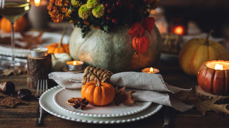A dinner table set with fall decorations