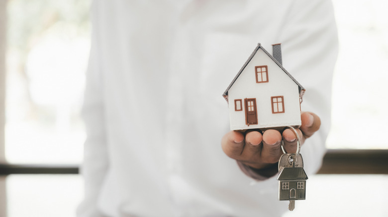 man holding house and keys