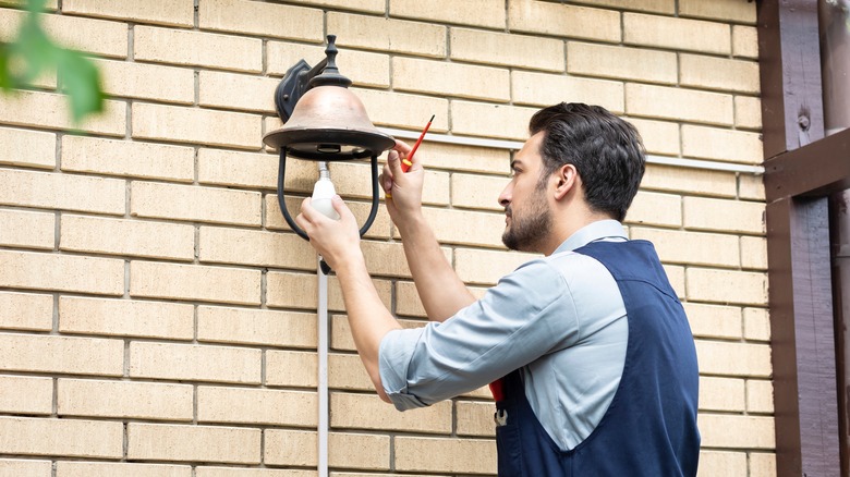 Man changing an outdoor light bulb