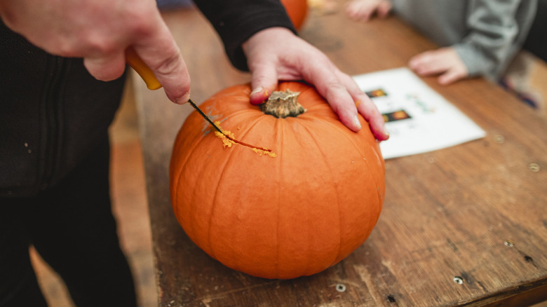 cutting top of pumpkin 
