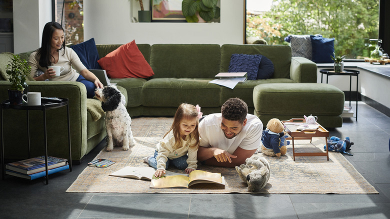 Father and daughter reading on living room floor