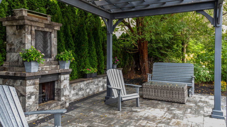 Stone patio with pergola and fireplace