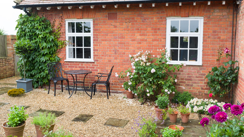 bistro table on gravel patio surrounded by flowers