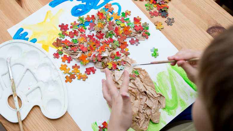 child creating tree puzzle art