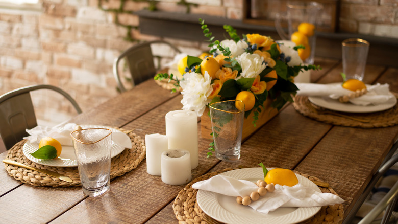A summer tablescape with a citrus-themed centerpiece in the middle.