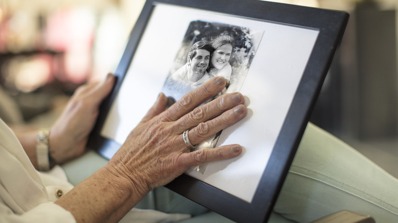 Woman touching black and white photo in frame