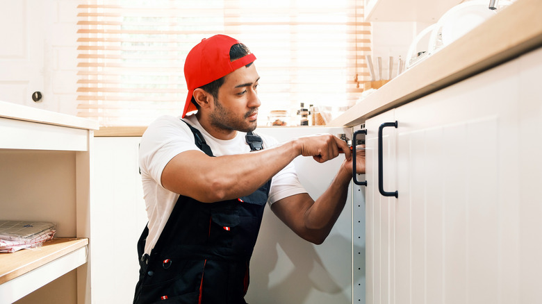 Handyman attaching kitchen handles
