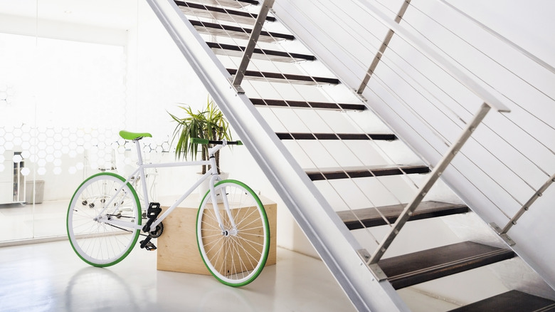 green-accented bike standing under a set of stairs