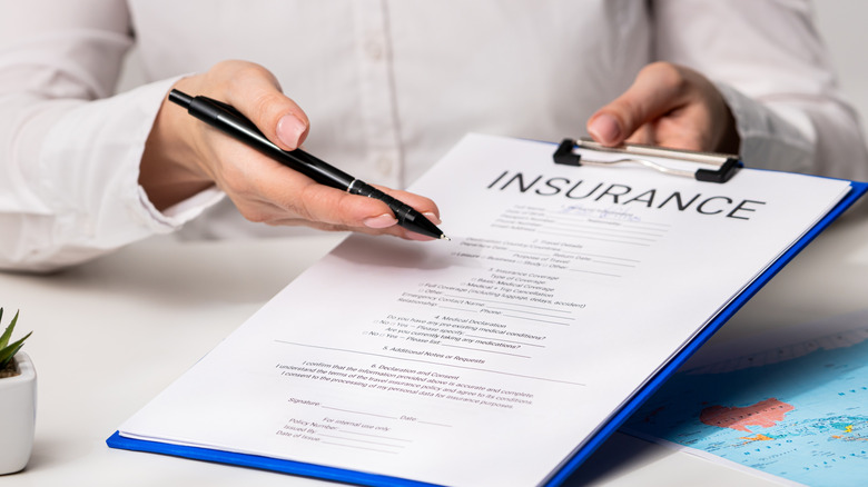 A person presenting a clipboard with an insurance policy