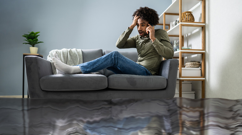 man on sofa in flooded home