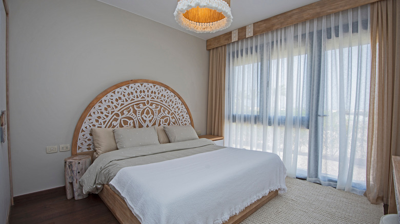 Simple bedroom with wall mounted curtain track system.