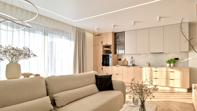 Simple, minimalist, bright living room. Ceiling curtain track system installed on sliding glass doors.