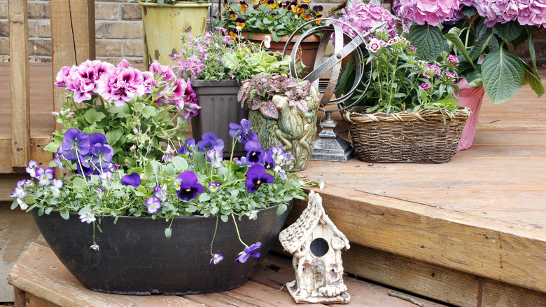 a porch with planters and a bird house decoration