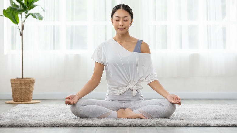 Woman meditating on yoga mat