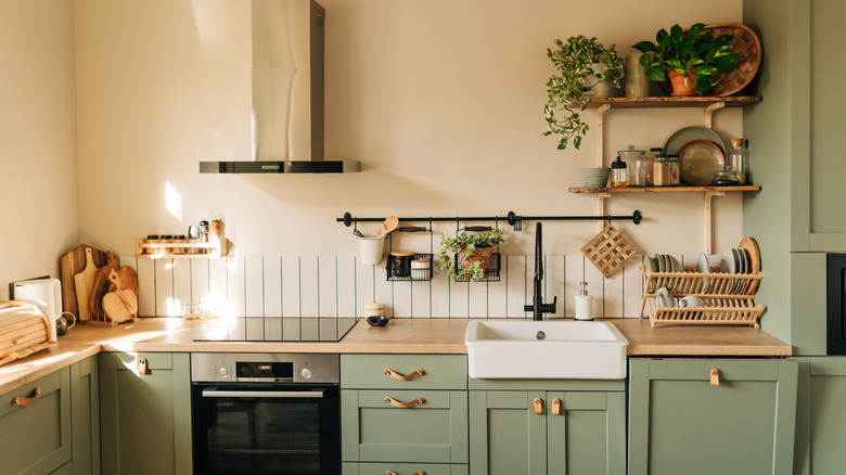Muted green kitchen with wooden countertops