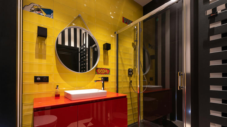 Bold yellow and black bathroom with red vanity and some pop art tiles