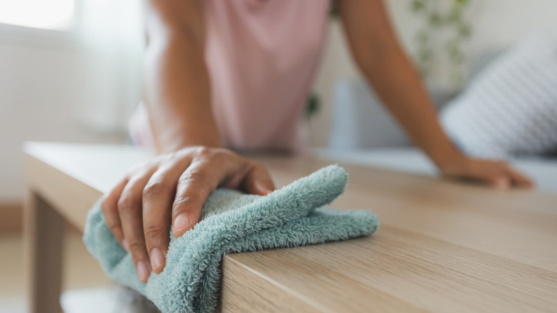 Woman wiping table with cloth
