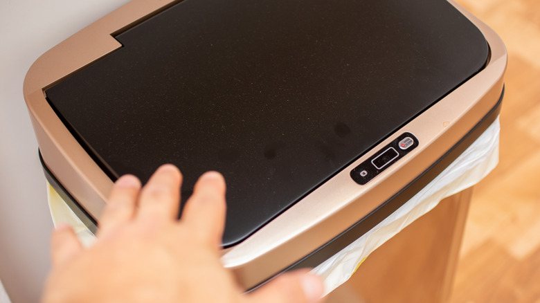Person touching sensor trashcan
