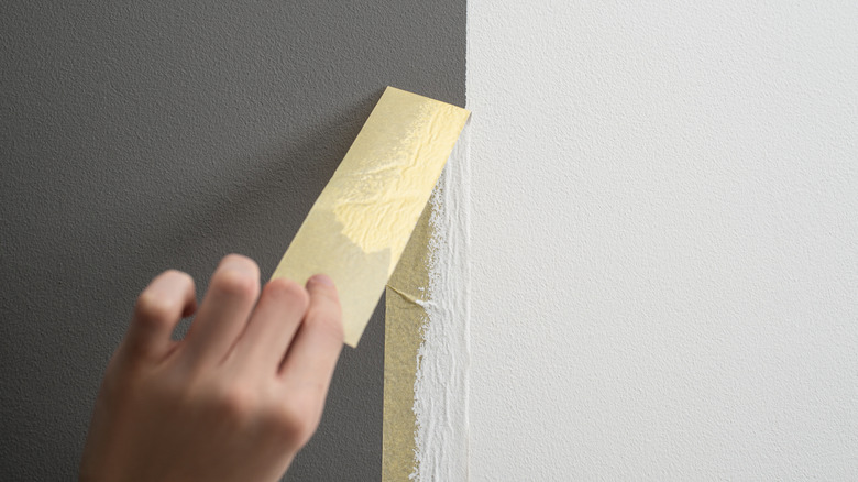 Person peeling tape off wall