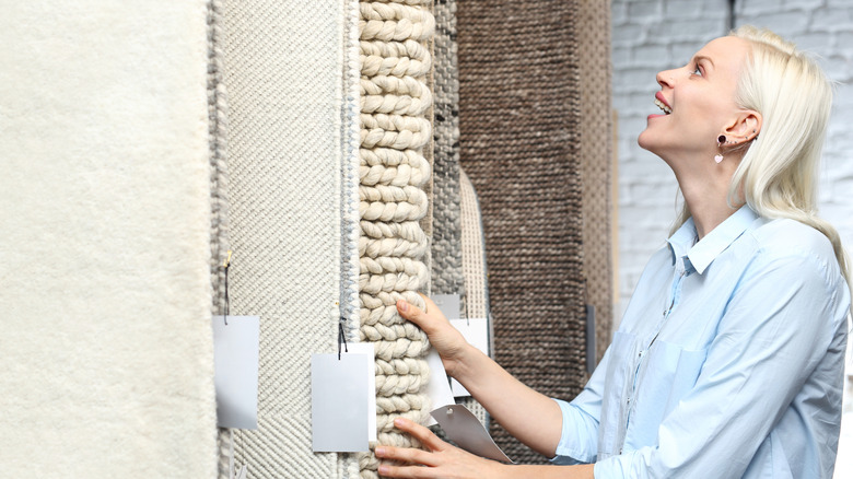 woman considering carpets in home goods store