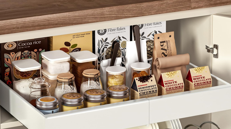 A pull out shelf with food and cookware in a cabinet