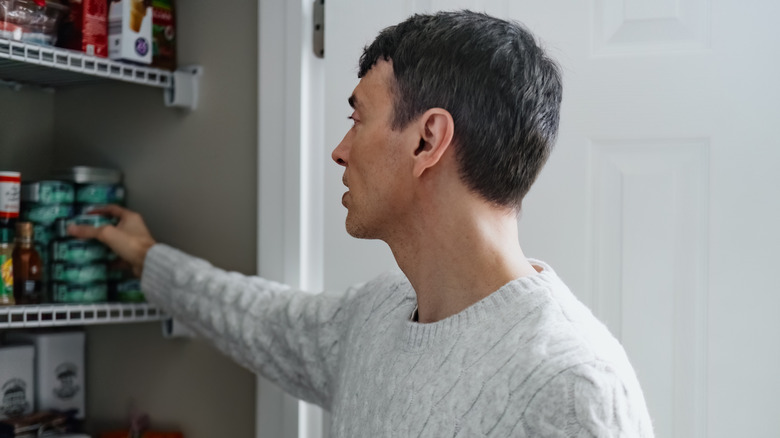 A man reaching into a pantry