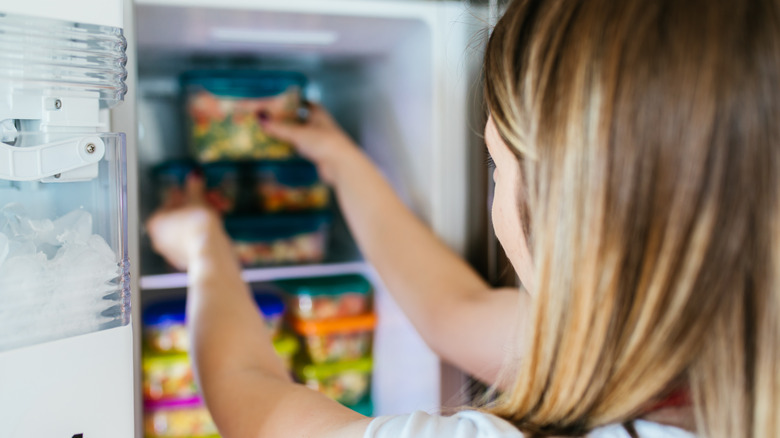 woman putting frozen food away