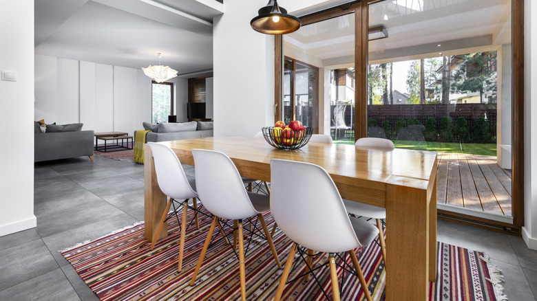 A dining table and chairs with a colorful rug underneath
