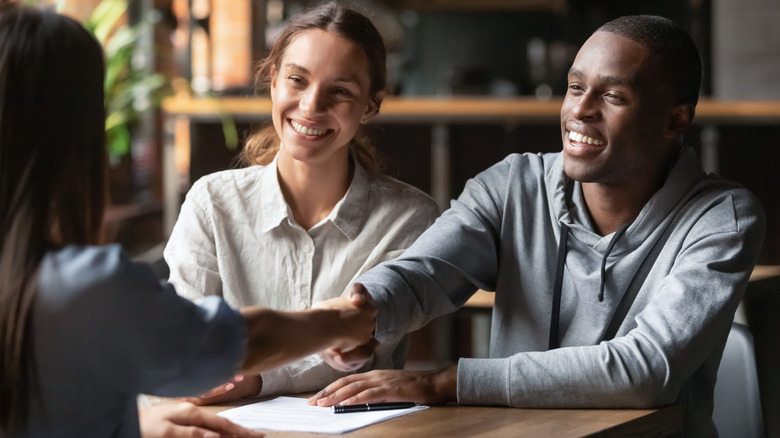 couple shaking hands with agent