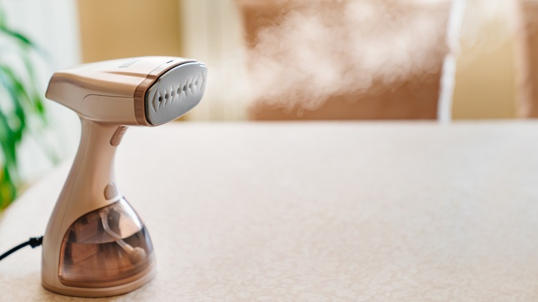 Hand held clothing steamer
