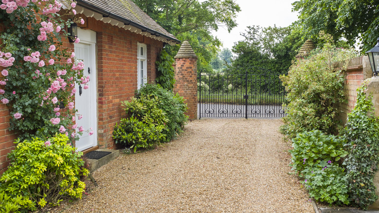 Gravel driveway beside a brick house