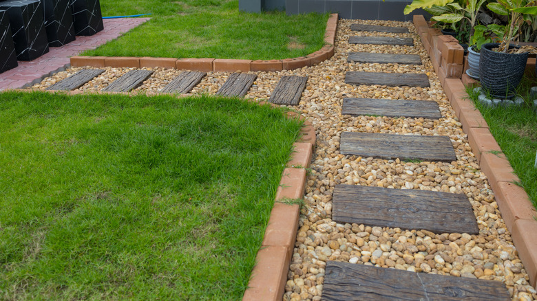 Backyard gravel walkway with wood planks