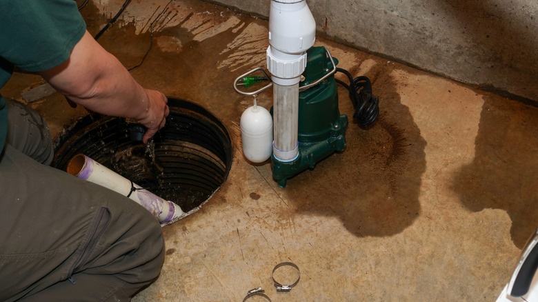 A man works on an overflowing sump pump