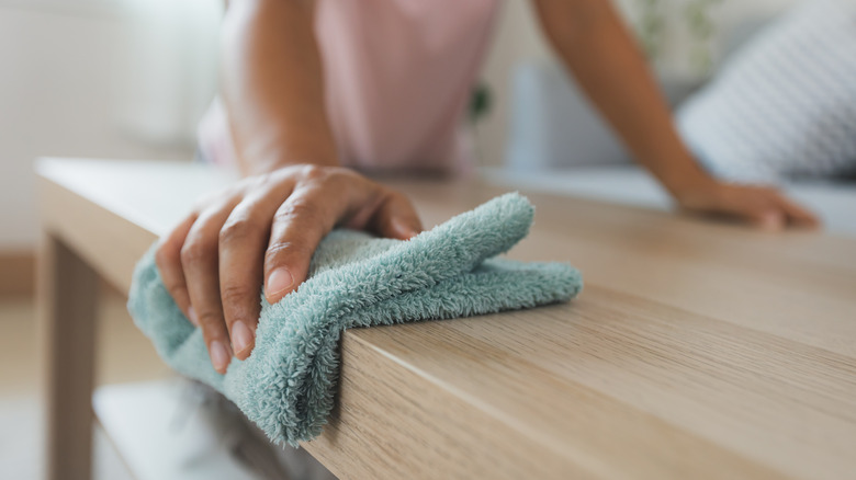 woman dusting with microfiber cloth